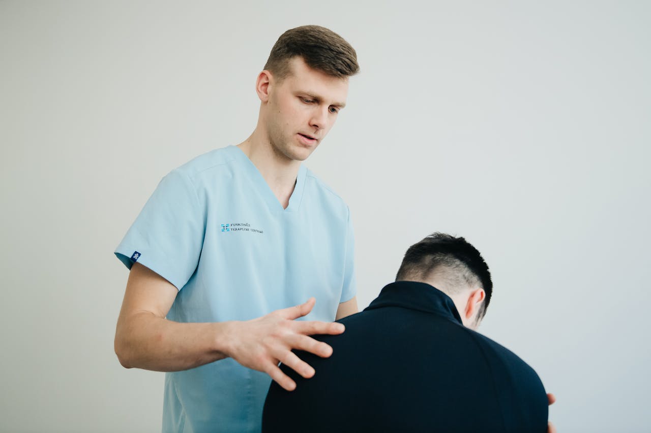 A physiotherapist assessing a patient's posture indoors, showing support and expertise.